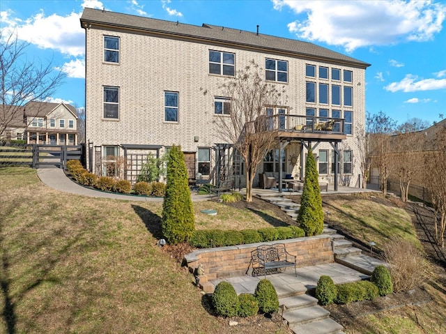 back of property with a patio area, fence, brick siding, and a yard