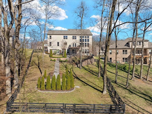 view of home's community with stairs, a fenced front yard, and a lawn