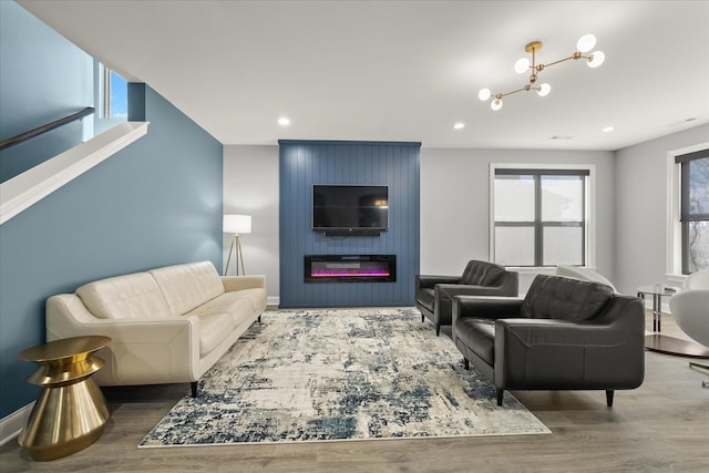 living room with a large fireplace, recessed lighting, wood finished floors, and baseboards