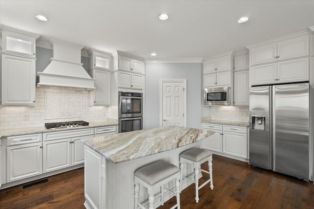 kitchen with premium range hood, appliances with stainless steel finishes, white cabinets, and dark wood-type flooring