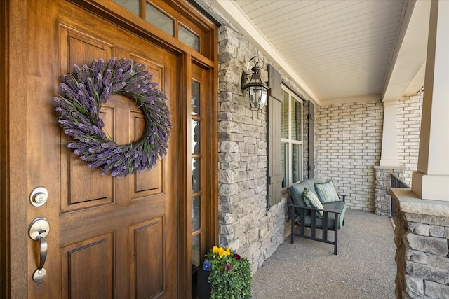 property entrance with covered porch and brick siding