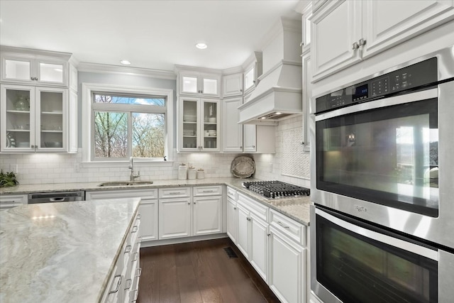 kitchen with premium range hood, a sink, white cabinetry, appliances with stainless steel finishes, and dark wood finished floors