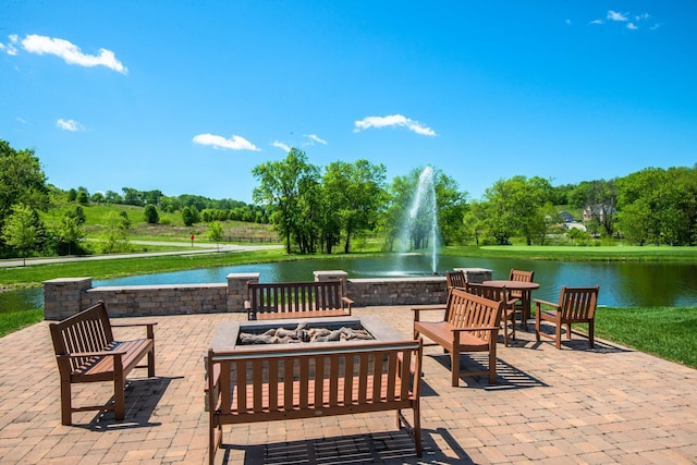 view of patio / terrace with a fire pit and a water view