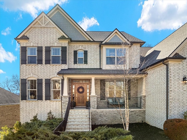 craftsman-style house with a porch and brick siding