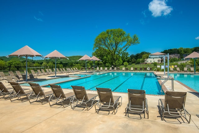 pool with fence and a patio