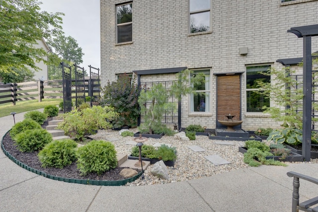 property entrance featuring brick siding and fence