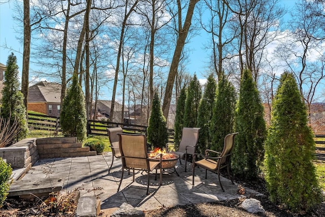 view of patio featuring fence and a fire pit