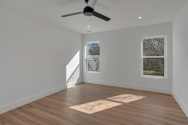 spare room with recessed lighting, wood finished floors, a ceiling fan, visible vents, and baseboards