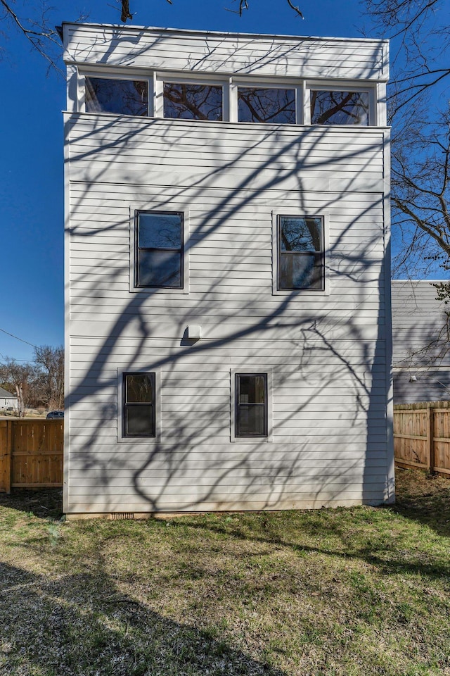 view of side of property with fence and a lawn