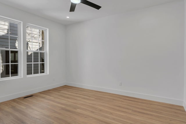 empty room with light wood-style floors, baseboards, visible vents, and ceiling fan