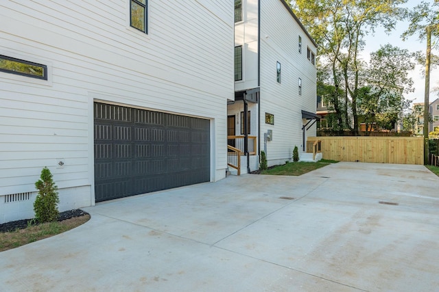 view of home's exterior featuring crawl space, fence, and concrete driveway