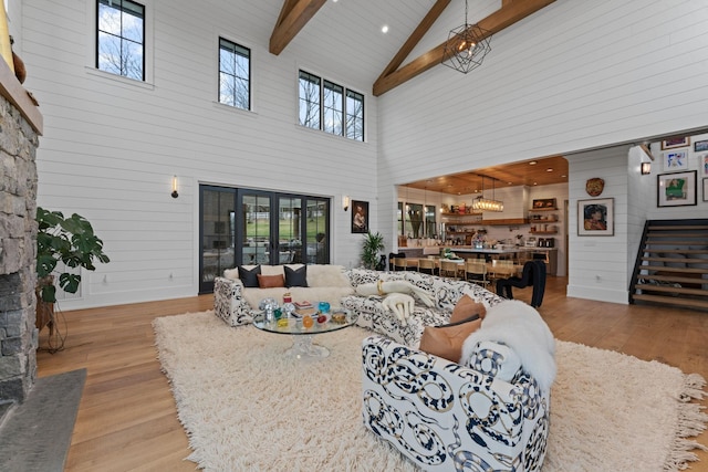 living area with high vaulted ceiling, beam ceiling, and wood finished floors