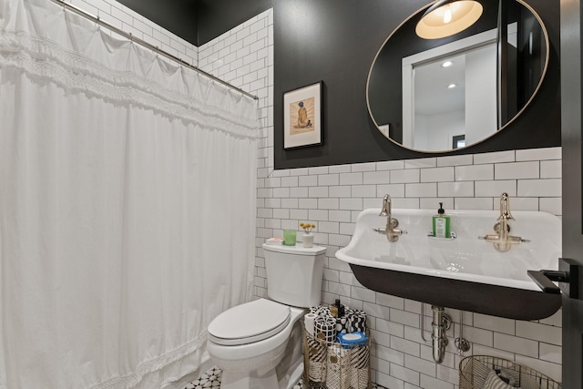 full bathroom with a shower with curtain, a sink, tile walls, and toilet