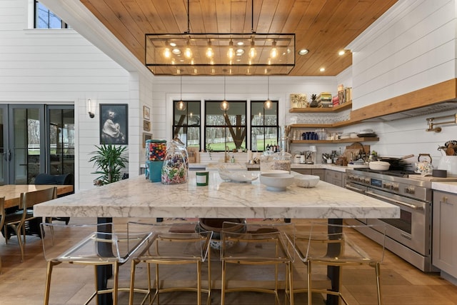 kitchen with wood ceiling, light stone counters, decorative light fixtures, high end stainless steel range, and open shelves