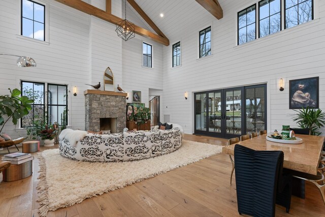 living room with plenty of natural light, beamed ceiling, wood-type flooring, and a fireplace