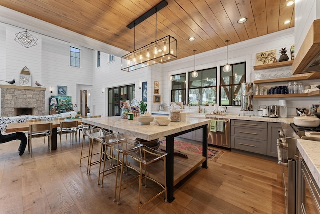 kitchen with hardwood / wood-style flooring, wood ceiling, high end stainless steel range, gray cabinetry, and open shelves