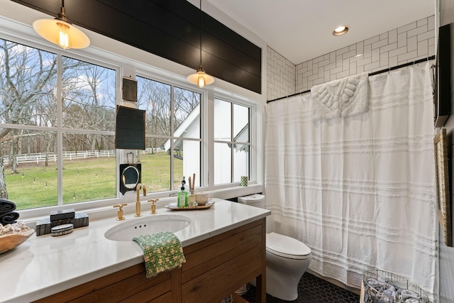 full bath featuring a wealth of natural light, a shower with curtain, vanity, and toilet