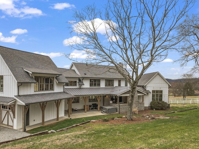 rear view of property featuring a yard, a chimney, board and batten siding, a patio area, and fence