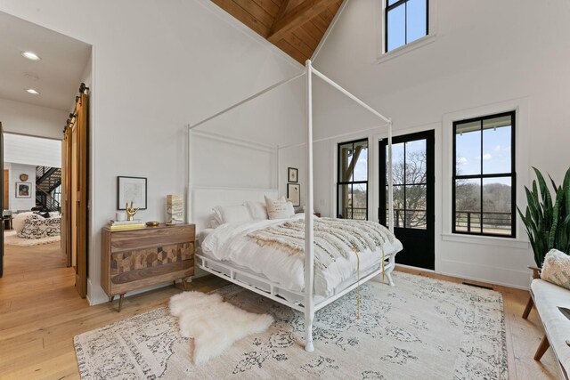 bedroom with a barn door, baseboards, visible vents, wood finished floors, and recessed lighting