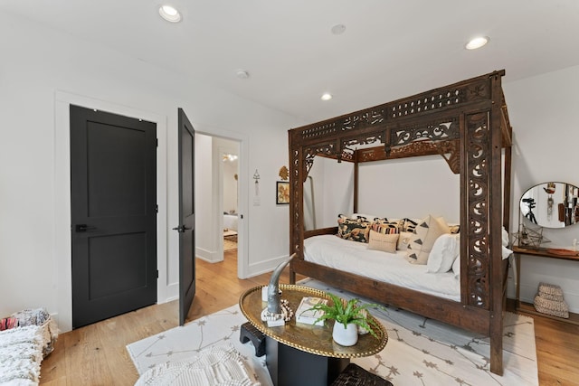 bedroom with baseboards, wood finished floors, and recessed lighting