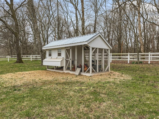 view of poultry coop featuring a yard and fence