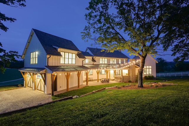 rear view of property featuring a patio, a yard, board and batten siding, and fence