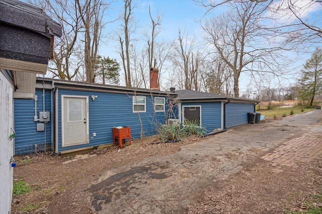 rear view of property featuring a chimney