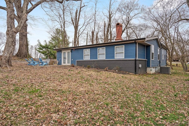 view of front of home featuring french doors, brick siding, and a chimney