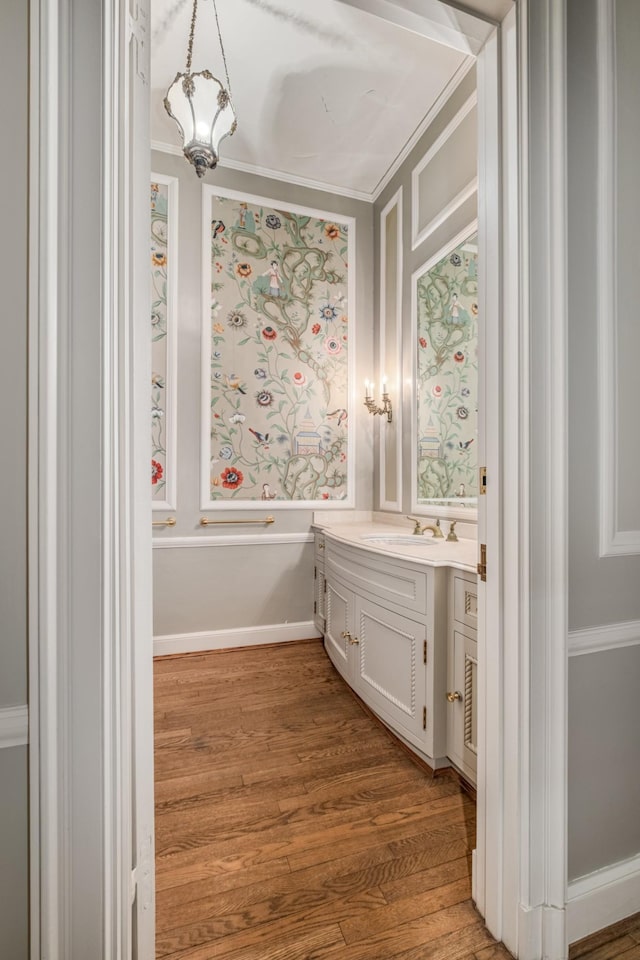 bathroom featuring ornamental molding, wood finished floors, and vanity