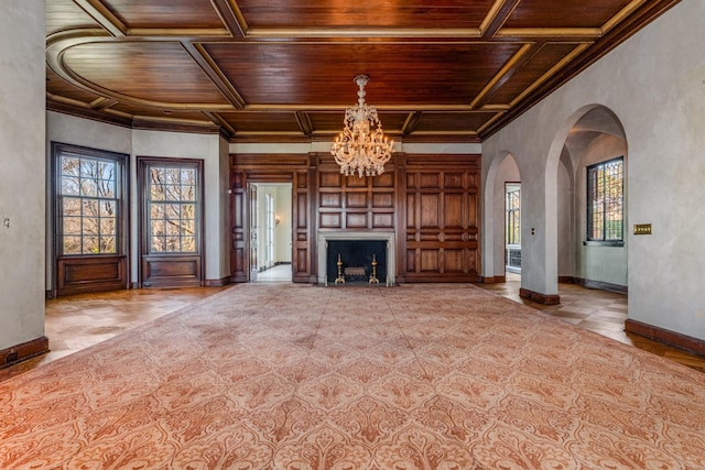 unfurnished living room with a healthy amount of sunlight, wooden ceiling, a fireplace, and baseboards