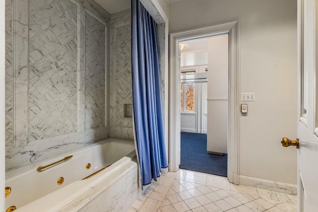 full bathroom with a jetted tub and baseboards