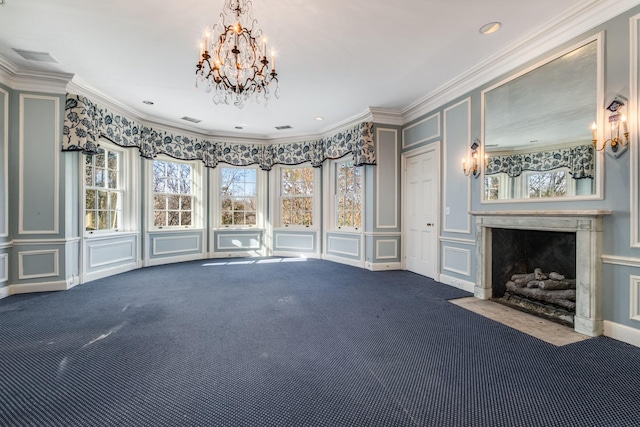 unfurnished living room with an inviting chandelier, carpet, crown molding, a decorative wall, and a high end fireplace