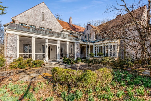 back of house featuring a sunroom and a balcony