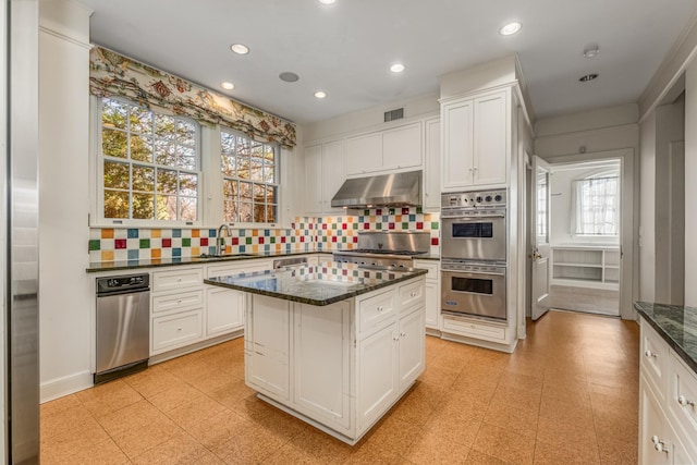 kitchen featuring visible vents, white cabinets, appliances with stainless steel finishes, under cabinet range hood, and a sink