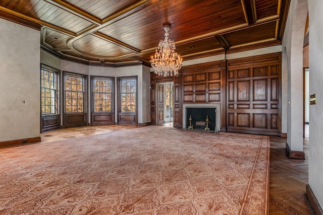 unfurnished living room featuring baseboards, wooden ceiling, a chandelier, and crown molding