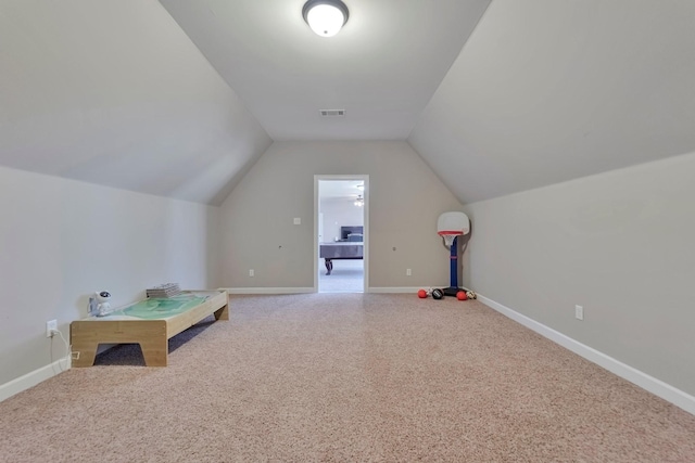 recreation room featuring carpet floors, visible vents, vaulted ceiling, and baseboards