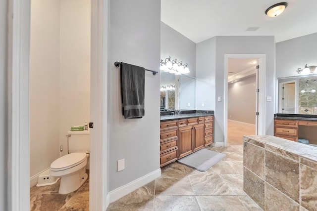 bathroom with baseboards, vanity, and toilet