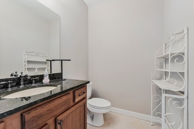 bathroom with toilet, tile patterned flooring, baseboards, and vanity