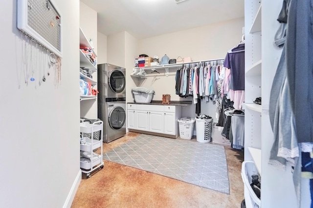 walk in closet with light colored carpet and stacked washer and clothes dryer