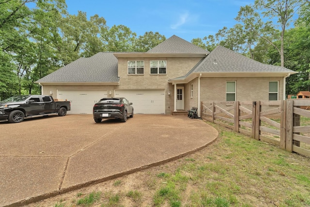 view of front of house with a shingled roof, fence, concrete driveway, and brick siding