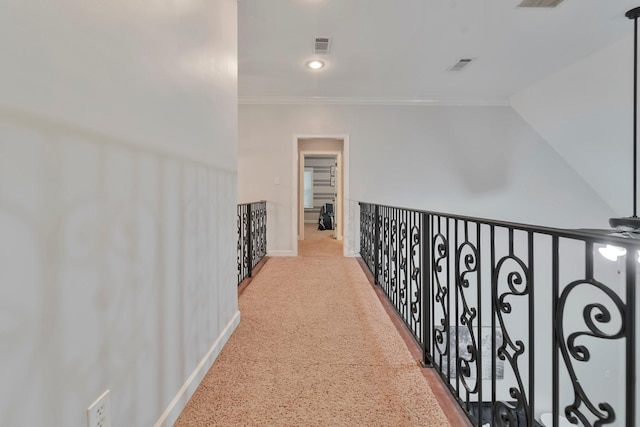 hallway with ornamental molding, visible vents, and baseboards