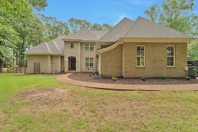 view of front of home featuring a shingled roof, a front yard, and fence