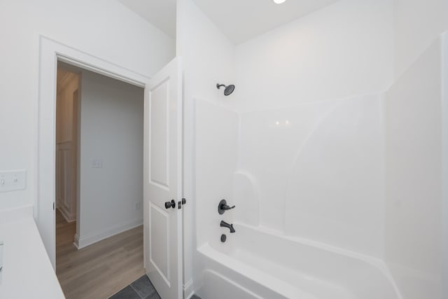 bathroom featuring  shower combination, baseboards, and wood finished floors