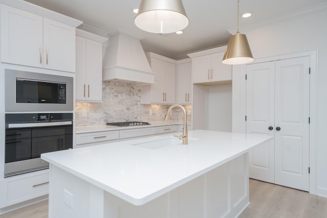 kitchen with appliances with stainless steel finishes, a sink, backsplash, and custom exhaust hood