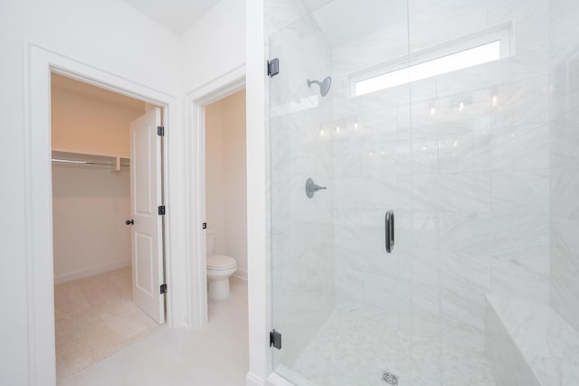 full bath featuring baseboards, a shower stall, and toilet