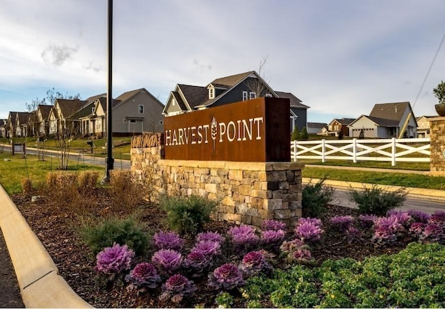 community sign featuring a residential view and fence