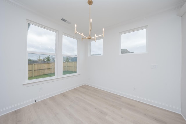 unfurnished room featuring light wood-style flooring, an inviting chandelier, visible vents, and baseboards