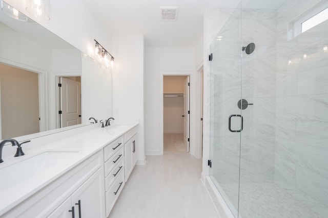 bathroom featuring a spacious closet, a sink, visible vents, and a shower stall