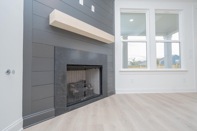 interior details with a fireplace, baseboards, and wood finished floors