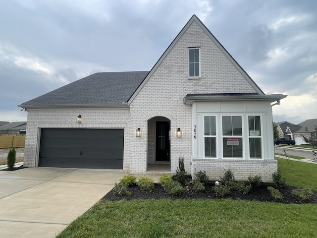 view of front of home featuring brick siding, driveway, and an attached garage